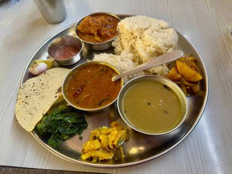 A traditional Nepali meal served on a metal tray.