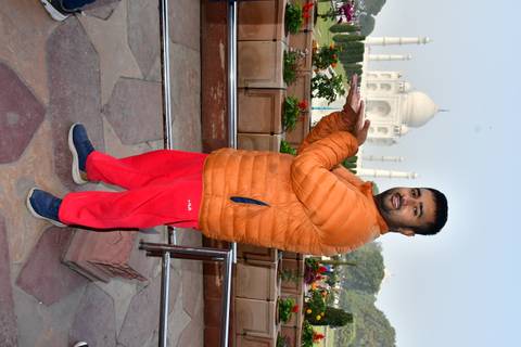 Person posing in front of the Taj Mahal.