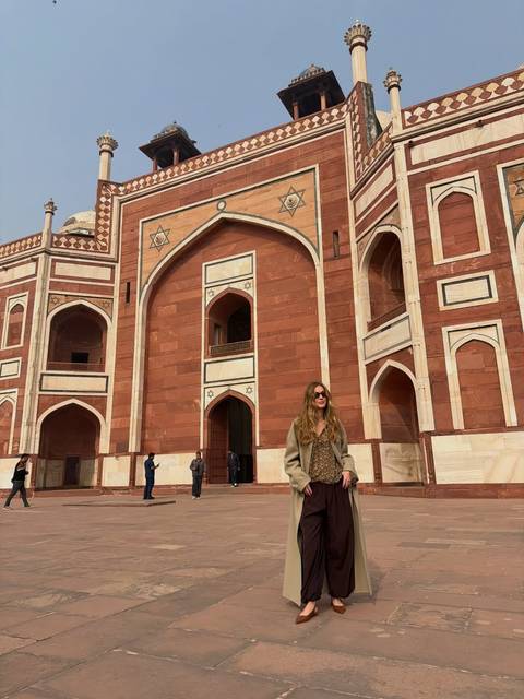 A woman standing in front of an impressive historic building.