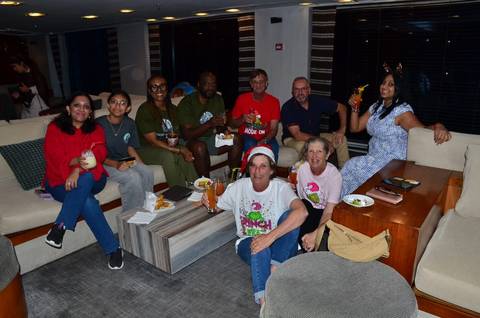 Group of people enjoying food and drinks in a cozy indoor setting.