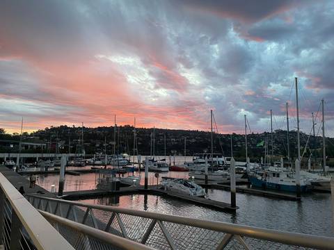 Docked boats at a marina during a colorful sunset.
