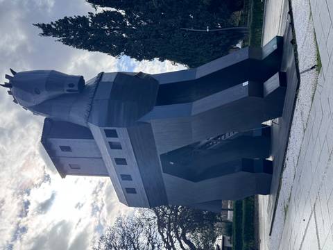 Giant wooden horse statue set in a park.