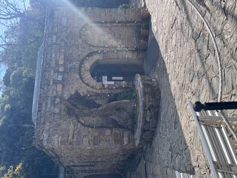 Stone arch entrance to a small historic building.