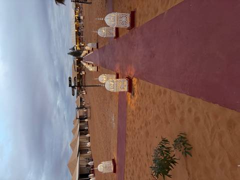 Desert camp with path lit by lanterns.