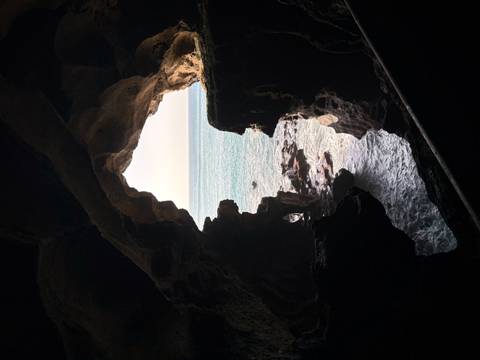 View of the ocean through a cave opening.