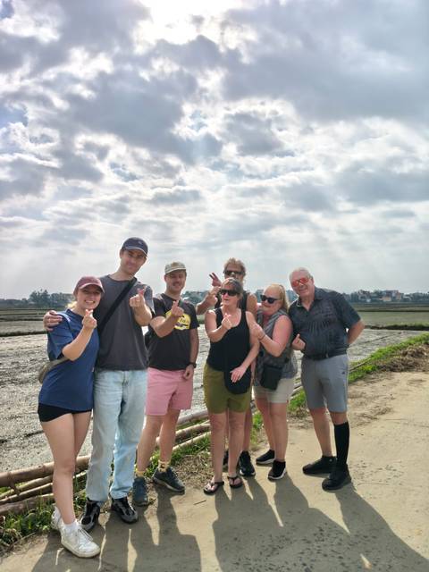 Group of people posing playfully in a rural outdoor setting.