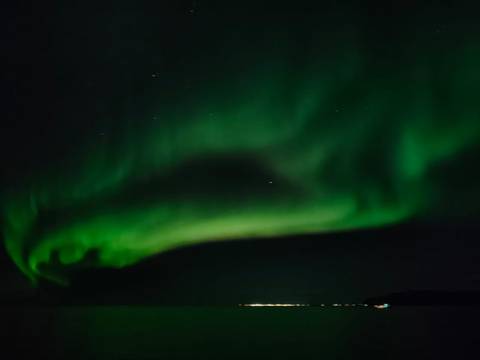 Night sky dominated by a large, swirling aurora borealis.