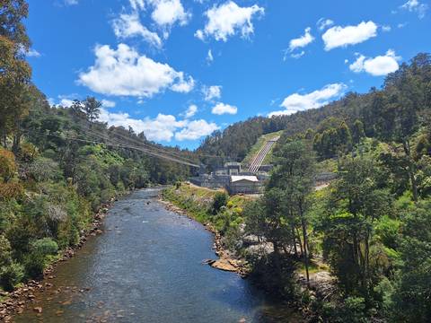 River with a dam structure in a forested setting.