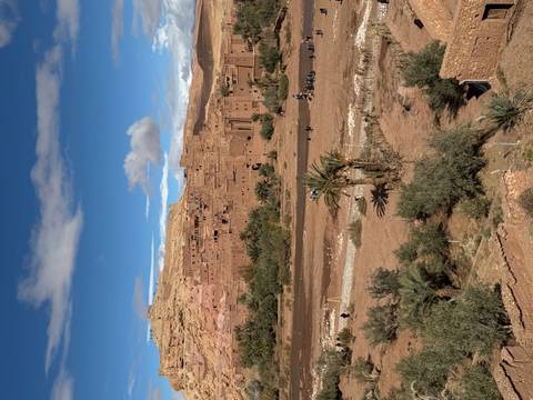 Classic view of the ancient city of Ait Benhaddou under a blue sky.