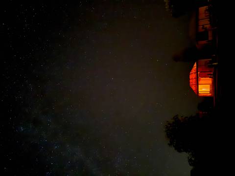 Night view of a tent with the Milky Way visible in the sky.