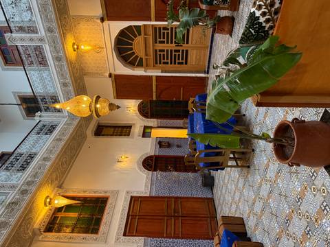 Beautifully decorated interior of a riad with traditional Moroccan tiles and lighting.