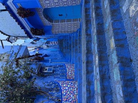 Charming blue-painted alleyway in a vibrant neighborhood.