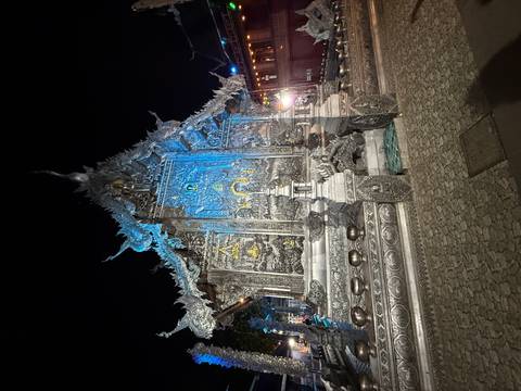 Illuminated silver temple at night.