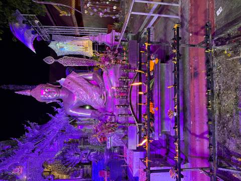 Buddha statue illuminated with purple lighting.