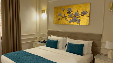Interior of a hotel room with a large bed and decorative artwork.
