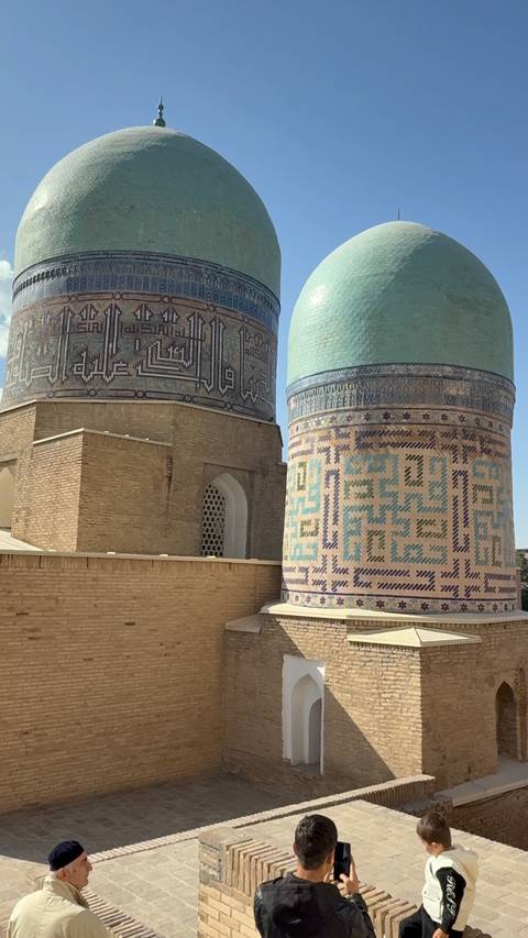 Exterior wall of a historic building with detailed blue mosaic patterns.