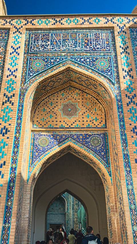 Close-up of a decorated archway with blue and gold tiles in a historic building.