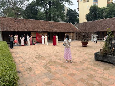 Group of people in traditional attire posing in a courtyard.