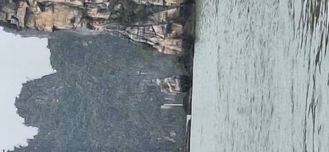 Blurry image of a scenic coastal area with cliffs and water.