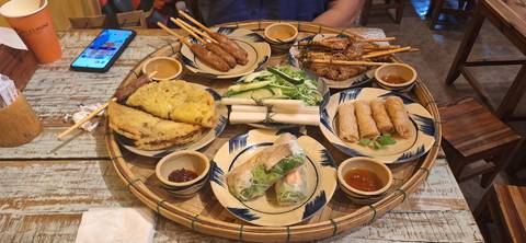 Plate filled with various Vietnamese dishes, served on a wooden table.