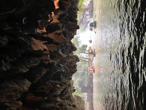 View from inside a cave overlooking boats on a river.