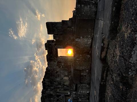 Setting sun perfectly framed through a stone doorway of an ancient Khmer temple ruin.