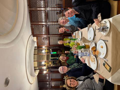Dinner table of travellers smiling inside a traditional Moroccan restaurant.