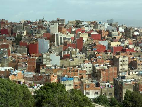 Panoramic view of densely packed colourful buildings sprawling across a hillside.
