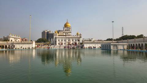 Golden-domed Sikh temple Gurudwara Bangla Sahib reflected in its sacred pool.
