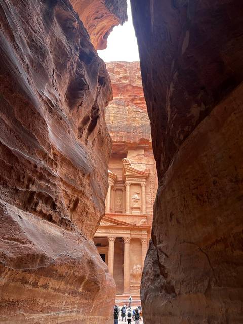 The Treasury of Petra dramatically revealed through the narrow sandstone walls of the Siq.
