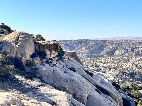 Wide rocky vista dotted with shrub-covered slopes and the skull rock in the distance.