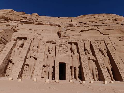 Sandstone façade of Abu Simbel’s smaller temple with row of standing deities.