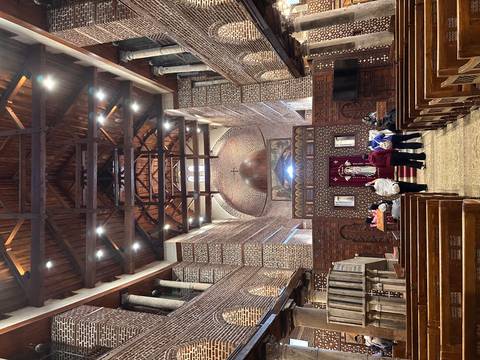 Wood-beamed interior of Cairo’s Hanging Church with visitors observing the altar