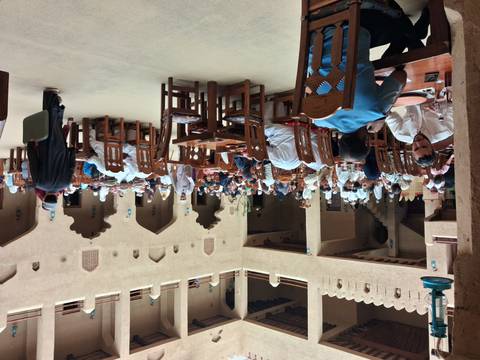 Large crowd of diners enjoy a traditional meal inside a historic Omani fort courtyard restaurant.