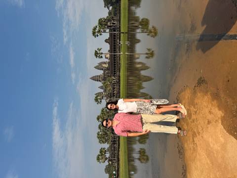 Couple standing by the reflecting pool with Angkor Wat in the background.