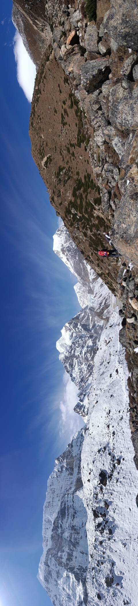 Snow-covered Himalayan ridge and deep blue sky captured in a dramatic wide angle.