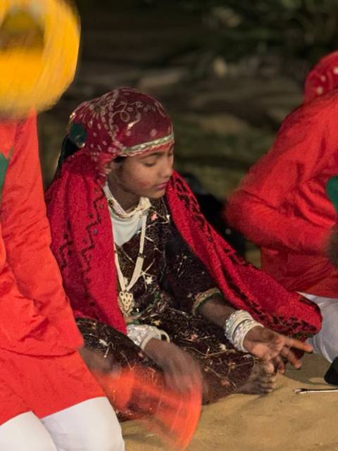 Young performer in bright traditional clothes during evening cultural show