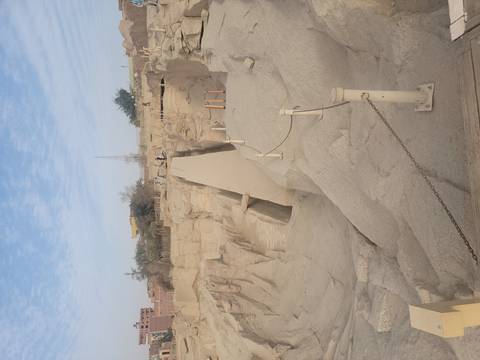 Granite quarry trench of unfinished obelisk with pale sky above.