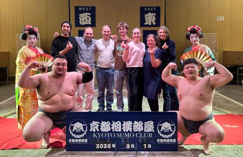 Group photo with sumo wrestlers and geisha performers inside the Kyoto Sumo Club arena.