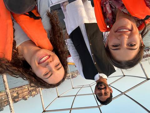 Smiling travellers wearing life jackets take a selfie on a boat ride along the Ganges in Varanasi.