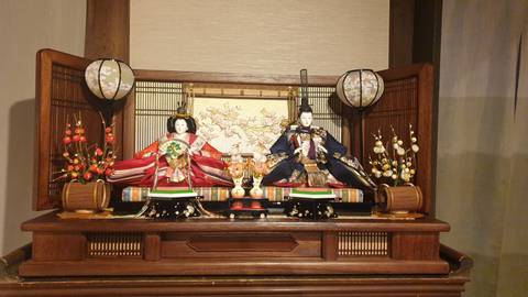 Traditional Japanese Hina-ningyo dolls displayed in an elegant wooden cabinet.