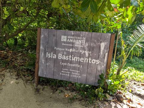 Wooden welcome sign for Parque Nacional Marino Isla Bastimentos set in tropical greenery.