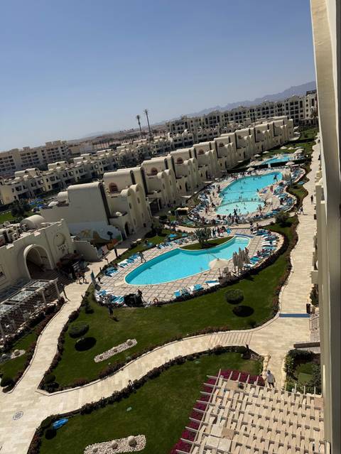 Aerial view of large resort complex with multiple pools and sun loungers in Hurghada.