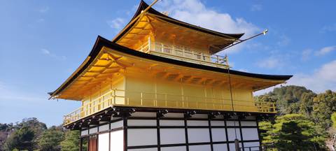 Golden Pavilion Kinkaku-ji gleaming under bright sunlight with clear blue sky.