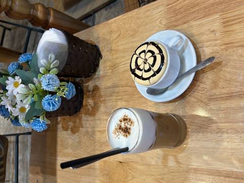 Egg coffee and iced coffee served on a wooden table with floral centerpiece