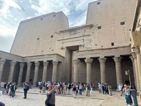 Interior courtyard of Edfu Temple with towering columns and crowds of visitors
