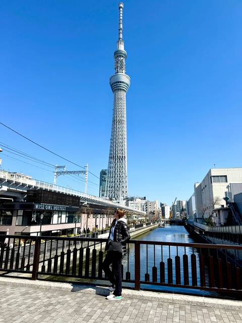 Traveler admiring the towering Tokyo Skytree under a bright blue sky