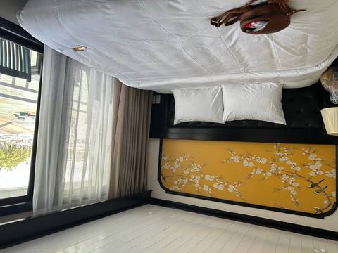 Bright, neatly made double bed in a cruise cabin with floral artwork above the headboard.