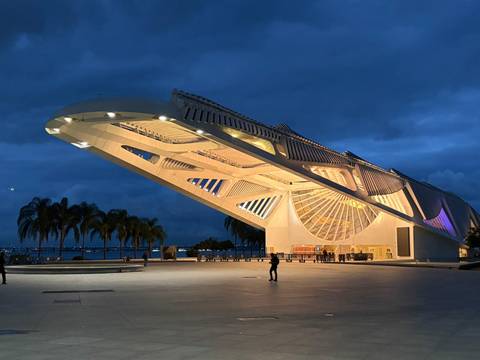 Illuminated Museum of Tomorrow in Rio de Janeiro glowing at dusk with a few visitors in the plaza.