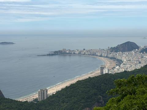 High viewpoint of Copacabana's sweeping beach curve meeting the calm Atlantic.